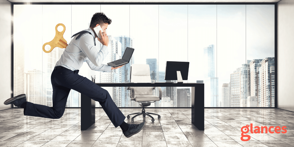 An effective way to start your workday Person sprinting across office holding a laptop with a windup mechanism in the back